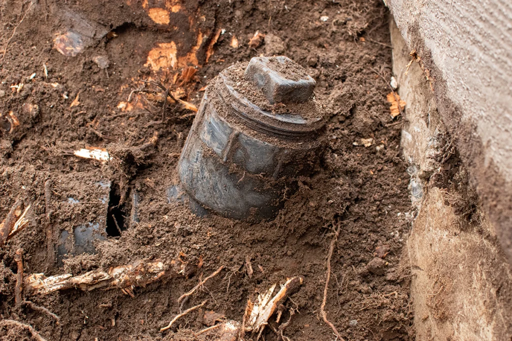 Exposed underground pipe and tree roots during sewer line repair in Hanover MA