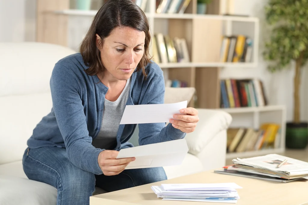 Homeowner wondering why her water bill is so high while reviewing a utility bill